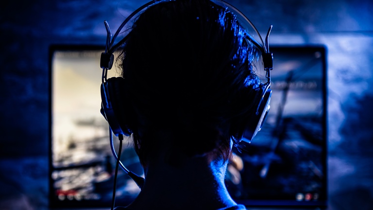 Eine Frau mit Kopfhörern nimmt ein Let’s Play als Screencast auf