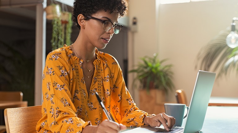 Für Einsteiger: In wenigen Schritten zum eigenen Screencast Eine Frau mit Laptop macht sich Notizen für einen Screencast