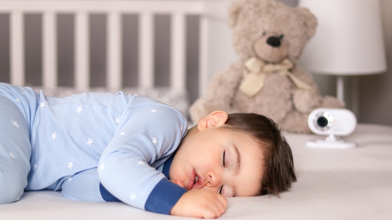 Kind schläft neben Video-Babyphone