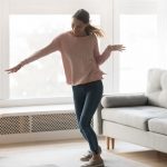 Eine Frau tanzt zu Musik aus ihrem Sonos-Lautsprecher im Wohnzimmer
