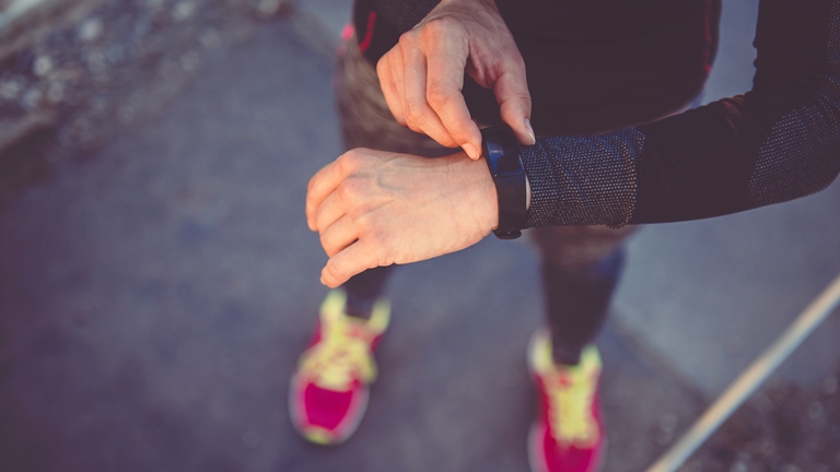 WhatsApp auf der Fitbit nutzen: So empfängst du Nachrichten Frau schaut auf Fitness-Tracker