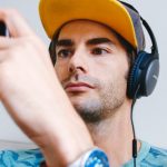 Mann mit Kopfhörern hält Smartphone