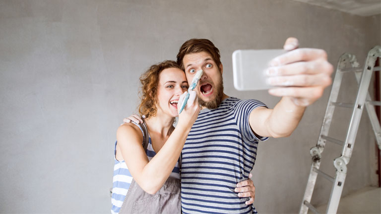 iPhone-11-Tricks: Diese Kniffe solltest du kennen Ein Mann und eine Frau machen während der Wohnungsrenovierung ein Selfie
