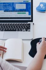 Frau an Laptop mit abgeklebter Kamera