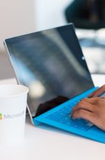 Frauenhände tippen auf einem blauen Laptop
