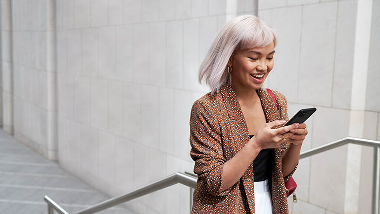 Eine Person läuft einen Gang entlang und schaut dabei auf ihr Google Pixel 5.
