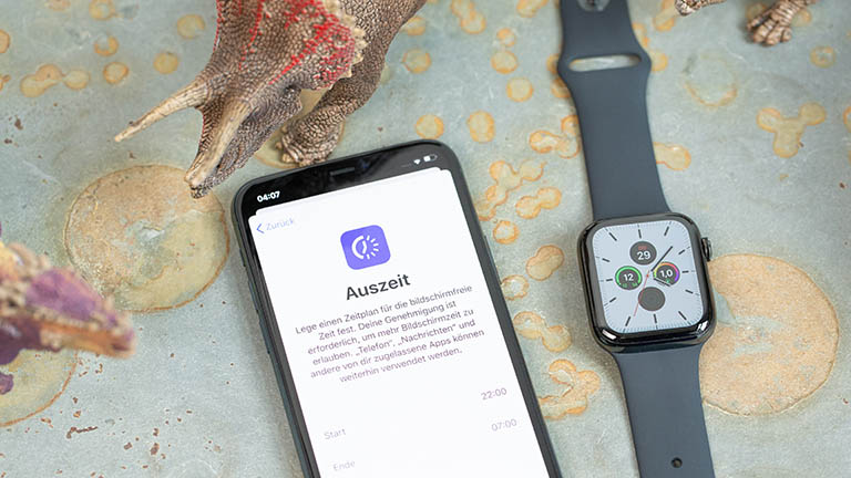 Apple Watch 5 iPhone und Apple Watch liegen nebeneinander. Auf der iPhone ist das Menü zur Einstellung der Auszeit-Funktion zu sehen.