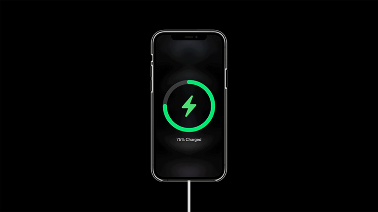 Apple iPhone 12 Pro Ein iPhone 12 lädt per MagSafe auf. Es ist bereits zu 75% geladen.