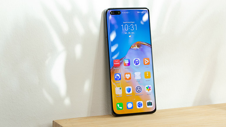 Huawei P40 Pro Ein Huawei P40 Pro steht aufrecht an der Kante eines Tisches.