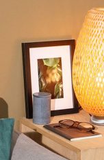 Eine IKEA-Lampe mit einer Tradfri-Birne. Daneben steht eine Hue-Bridge.