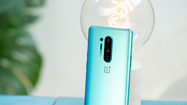 Das OnePlus 8 Pro an eine Glühbirne gelehnt. Zu sehen ist die Rückseite mit ihren vier Kameras.