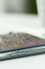 Das iPhone 11 ist mit Wasser bedeckt. Daneben steht ein Glas.