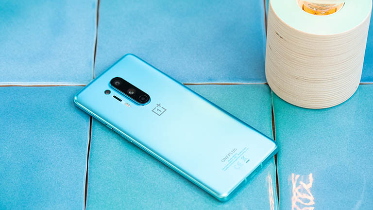 OnePlus 8 Pro Ein OnePlus 8 Pro liegt mit dem Display nach unten auf einer blauen Kachel.