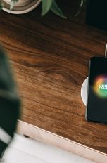 Ein Smartphone liegt auf einer Ladestation und lädt per Induktion auf.