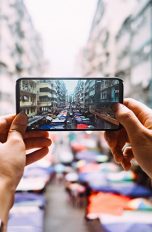 Eine Person hält ein Smartphone in der Hand und macht ein Foto.