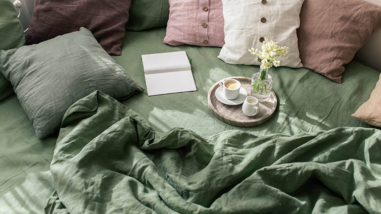 Bettwäsche, Leinen, Schlafzimmer Eine Decke und zahlreiche Kissen auf einem Bett.