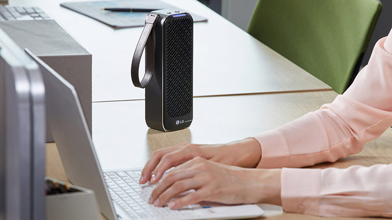 LG PuriCare Mini Der Mini-Luftreiniger aus der PuriCare-Reihe von LG auf einem Tisch im Büro.