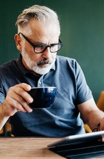 Eine Person sitzt in einem Café und bedient ihr iPad.