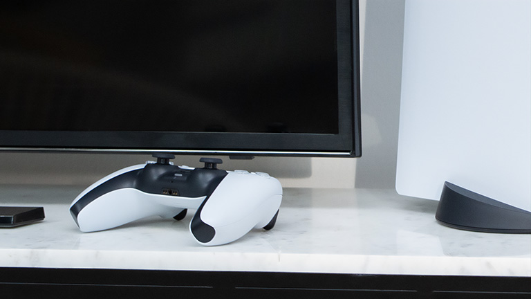 Ein DualSense-Controller neben einer PS5-Konsole.