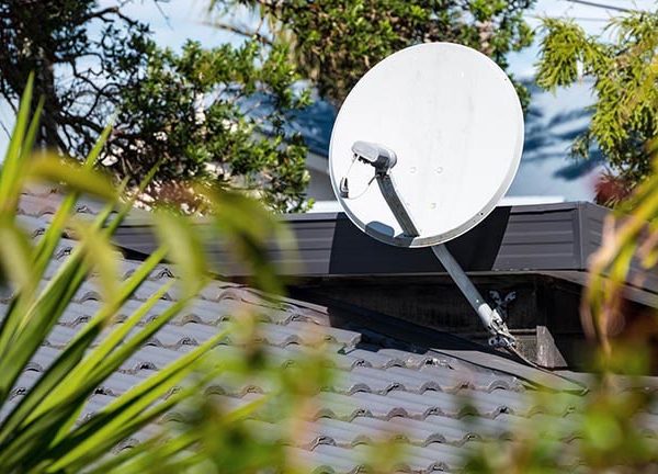 Eine Satellitenschüssel, die auf dem Dach eines Hauses angebracht ist.