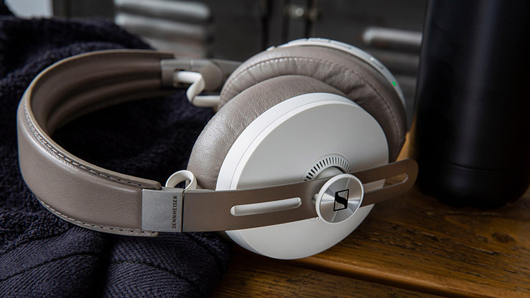 Sennheiser Momentum Wireless 3 Die Sennheiser Momentum Wireless 3 liegen auf einer hölzernen Oberfläche.