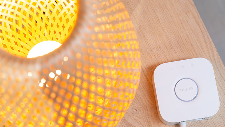 Philips Hue Eine Lampe mit smarter Glühbirne und eine Philips-Hue-Bridge.