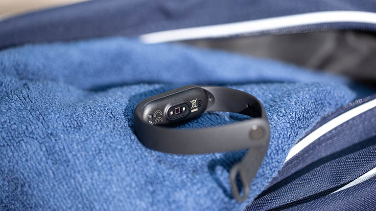 Xiaomi MI Smart Band 5 Das Xiaomi Mi Smart Band 5 liegt auf einem blauen Handtuch. Zu erkennen ist die Unterseite des Armbands und der darin verbaute Sensor für die Herzfrequenzüberwachung.