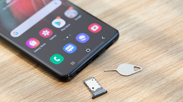 Samsung Galaxy S21 Ultra 5G Das Samsung Galaxy S20 liegt auf einem Tisch. Der SIM-Schlitten liegt unterhalb des Geräts.