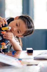 Ein Kind bastelt an einem elektronischen Spielzeug zum Selberbauen.