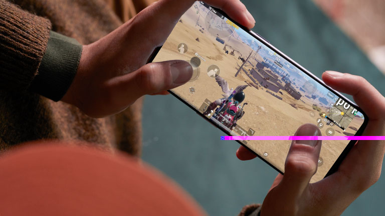 OnePlus 9 Eine Person hält eine OnePlus 9 quer in beiden Händen und spielt darauf ein Spiel.
