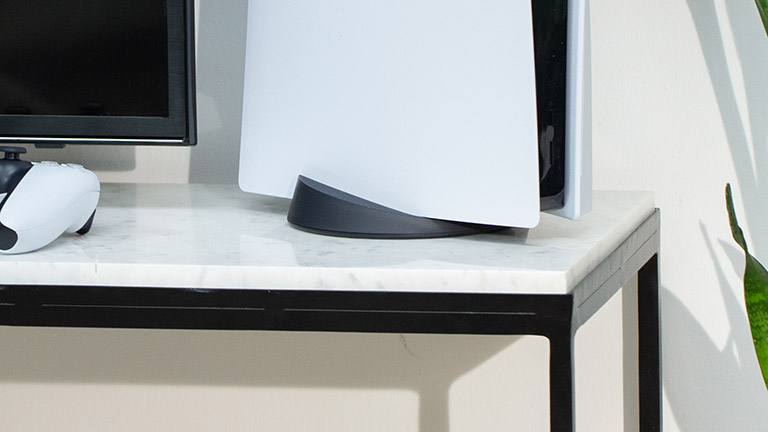 PS 5 einrichten Naheaufnahme des PS5-Standfußes, in dem die Konsole hochkant hineingestellt ist.