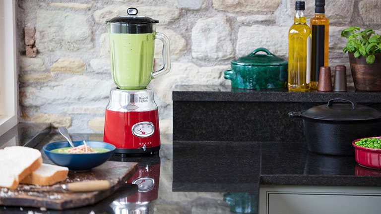 Russel Hobbs Standmixer Auf einer Küchenzeile steht der Retro-Standmixer von Russell Hobbs, in dem etwas zubereitet wird.