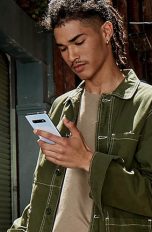 Eine Person hält ein Samsung Galaxy S10 in der Hand, während sie draußen unterwegs ist.
