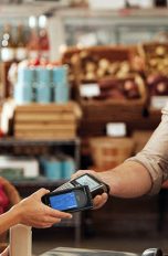 Eine Person bezahlt in einem Lebensmittelgeschäft mit dem Smartphone.