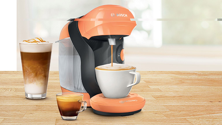 Tassimo entkalken Ein Bosch Tassimo in Orange, aus der gerade frischer Kaffee in eine Tasse fließt.