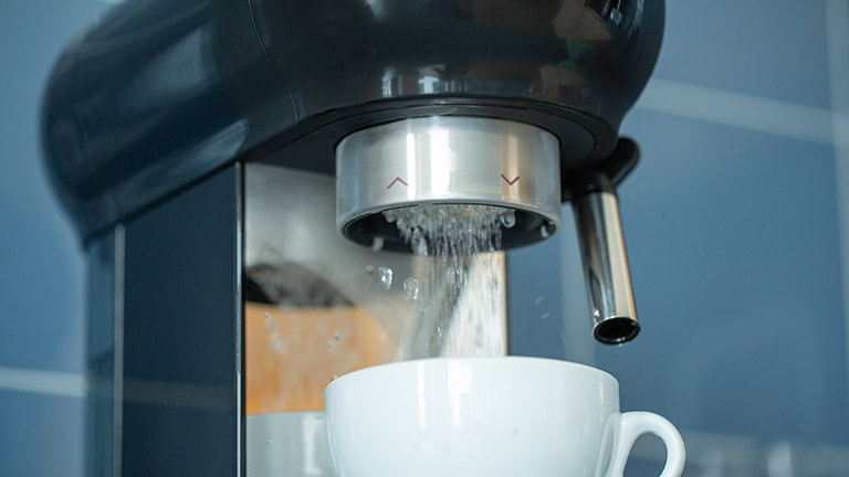 Espressomaschine entkalken Nahaufnahme der Brühgruppe an einer Smeg-Espressomaschine.