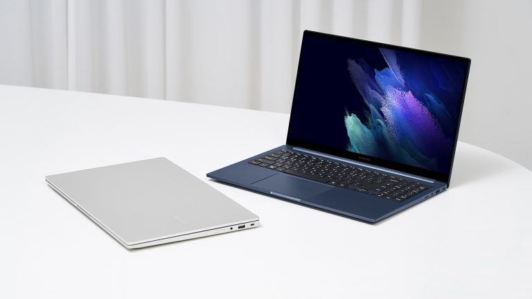 Samsung Galaxy Book Zwei Galaxy Books auf einem Tisch. Ein Gerät ist zu- eines ist aufgeklappt.