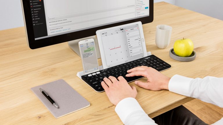Logitech K780 Eine Person nutzt eine Logitech K780 an einem iMac, iPhone und iPad gleichzeitig.