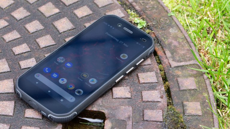 Cat S42 Das Outdoor-Smartphone Cat S42 liegt auf einem Kanaldeckel, das Display ist eingeschaltet.