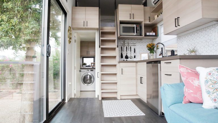 Tiny House Blick in den Wohn-/Schlaf/Küchen-Bereich eines Tiny Houses mit einer versteckten Waschküche.