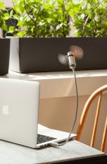 Der Hama USB-Ventilator an einem MacBook, das auf einem Tisch auf einem Balkon steht.