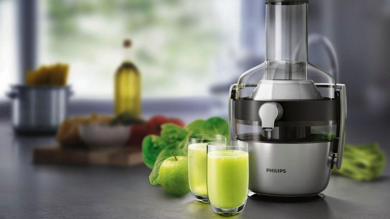 Philips Entsafter HR1921 Der Philips Zentrifugal-Entsafter steht auf einer Küchenarbeitsplatte. Vor ihm stehen zwei Gläser mit einem dickflüssigen grünen Saft.