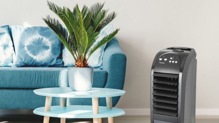 Bestron Luftkühler Ein Raum mit einem Sofa und einem kleinen Sofatisch. Daneben steht der Bestron Summer Breeze.