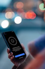 Eine Frau blickt auf ihr iPhone. Darauf ist die Einrichtung für Face ID zu sehen.