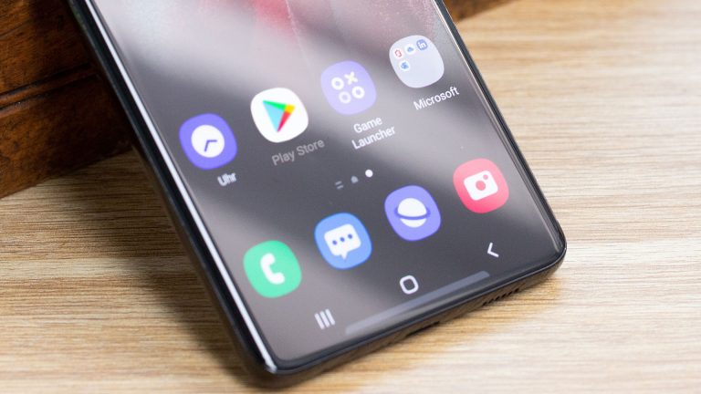 Ein Smartphone lehnt an einem Gegenstand. Im Detail ist auf dem Bildschirm der Google Play Store zu sehen.