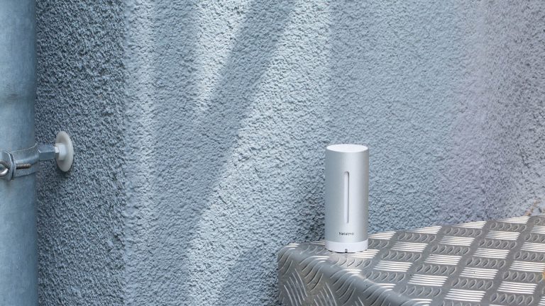 Netatmo Wetterstation Auf einem Tisch an der Hauswand steht eine Wetterstation von Netatmo.