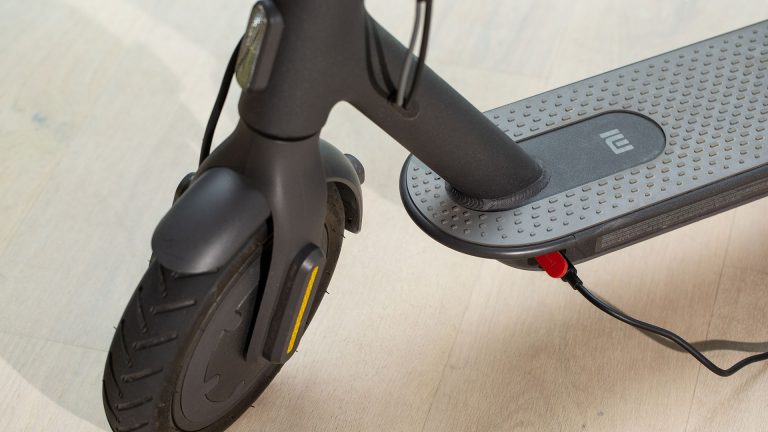 Mi Scooter 1S in Xiaomi Mi Electric Scooter 1S wird aufgeklappt. Gut zu erkennen sind die Reflektoren an der Seite des Vorderrads.