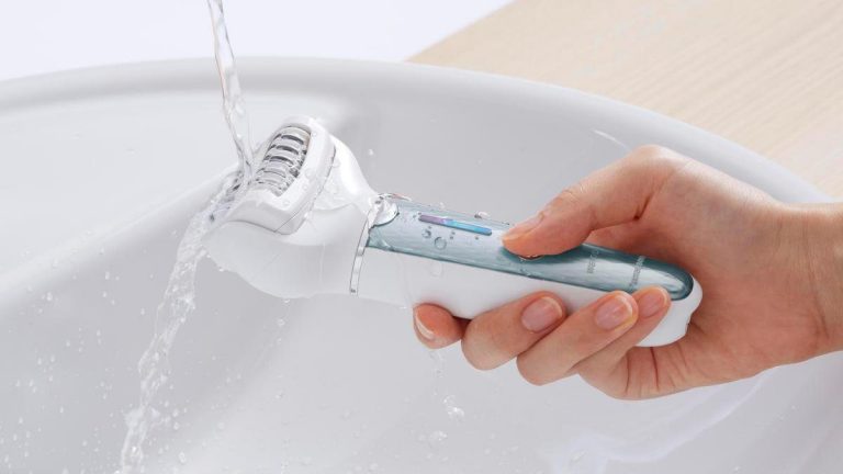 Panasonic ES EL2A Eine Hand hält den Panasonic Epilierer ES-EL2A unter den Wasserstrahl eines Waschbeckens.