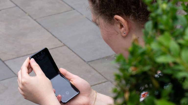 Samsung Galaxy Z Flip2 Eine Person hält ein nicht ganz geöffnetes Samsung Galaxy Z Flip in den Händen.