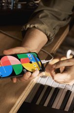 Eine Person hält das Google Pixel 5a in der Hand, das per USB-C aufgeladen wird.